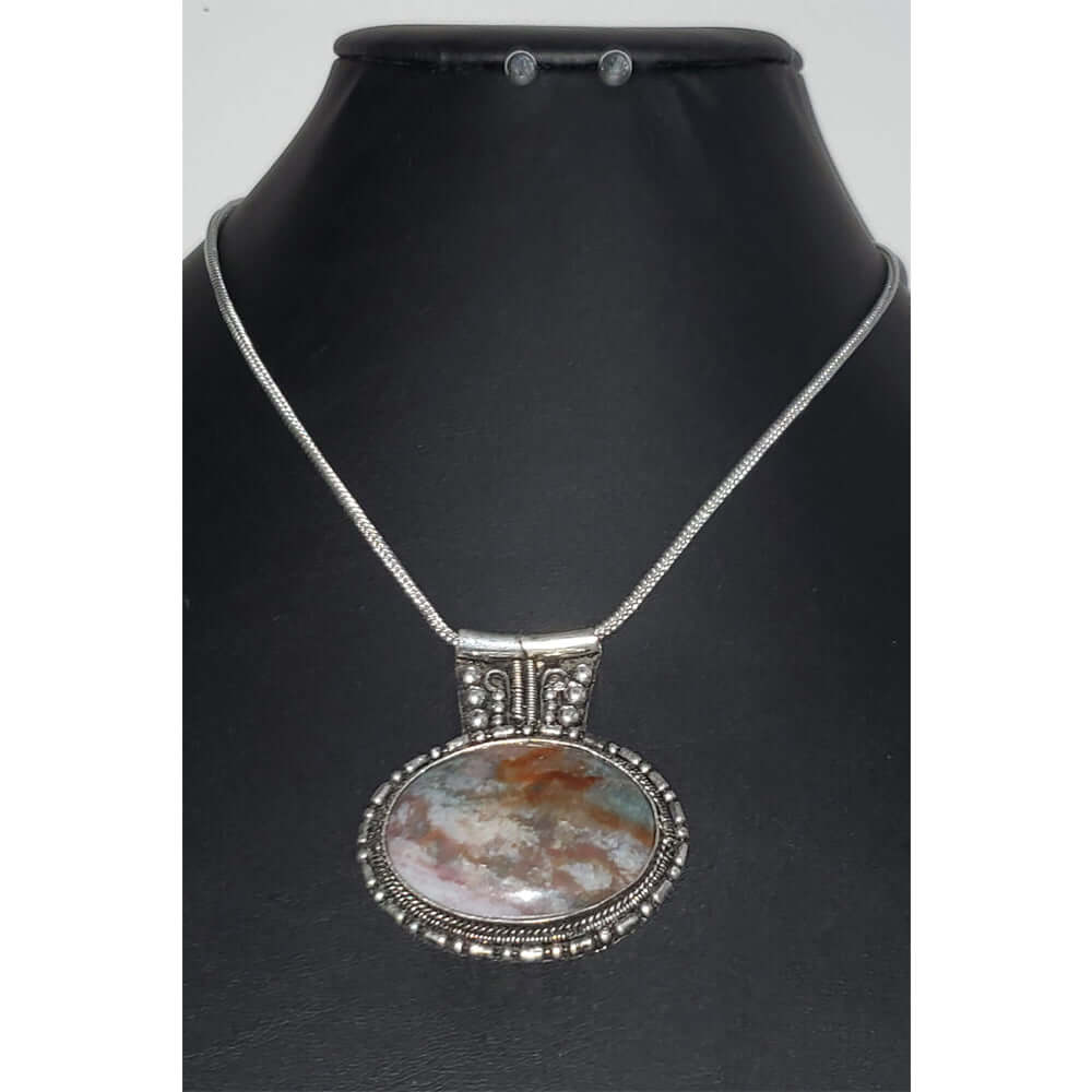 Agate oval pendant with a silver tone frame on a snake link chain. Necklace measures 21″ with a lobster claw clasp and extension. 