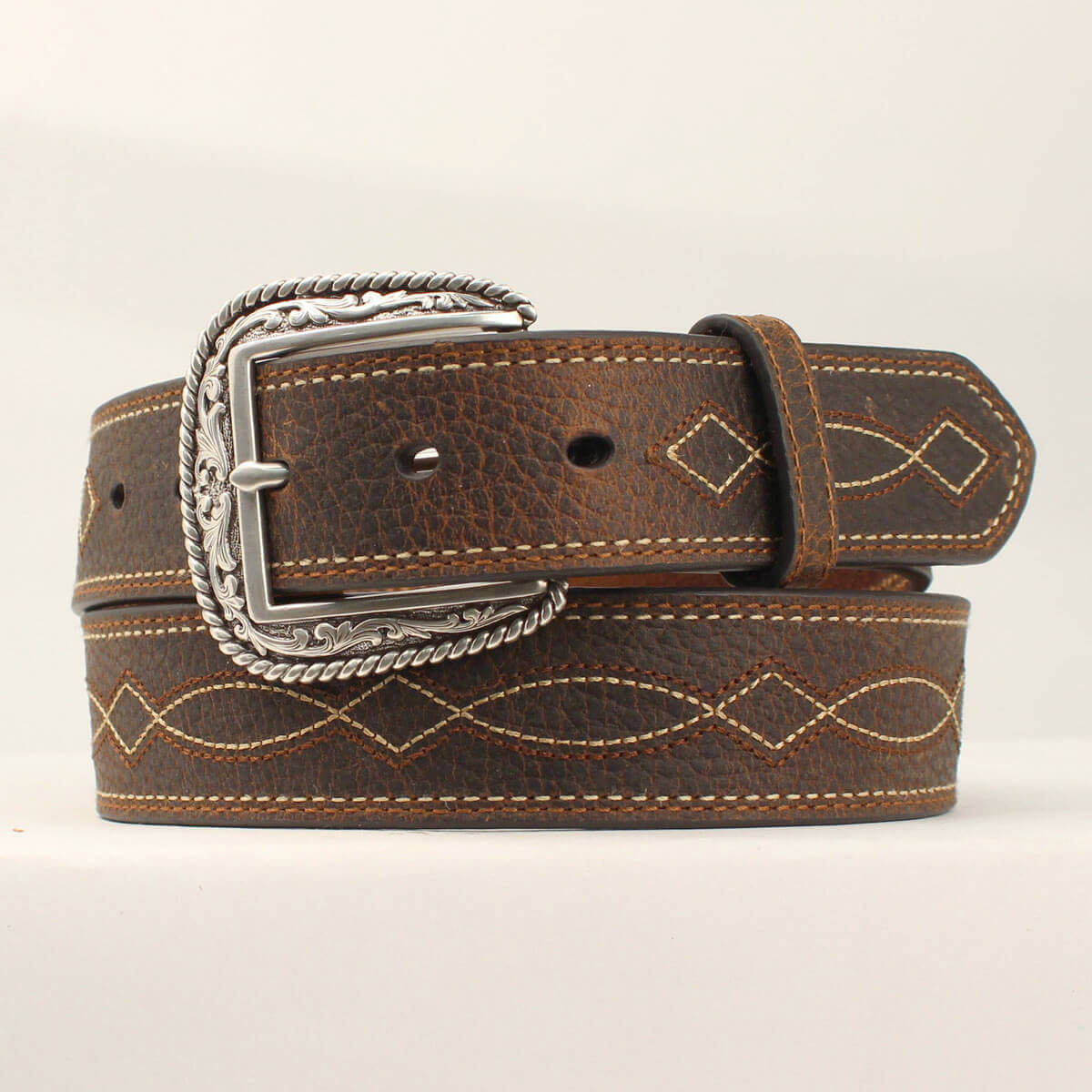 This men's Ariat belt has a rugged look, but is practical for every day wear. The brown strap has a tan boot stitch design down the center, and is complete with a silver etched buckle. This quality belt looks great and is designed for any occasion. Measures 1-1/2" wide. Removable Buckle. Imported.
