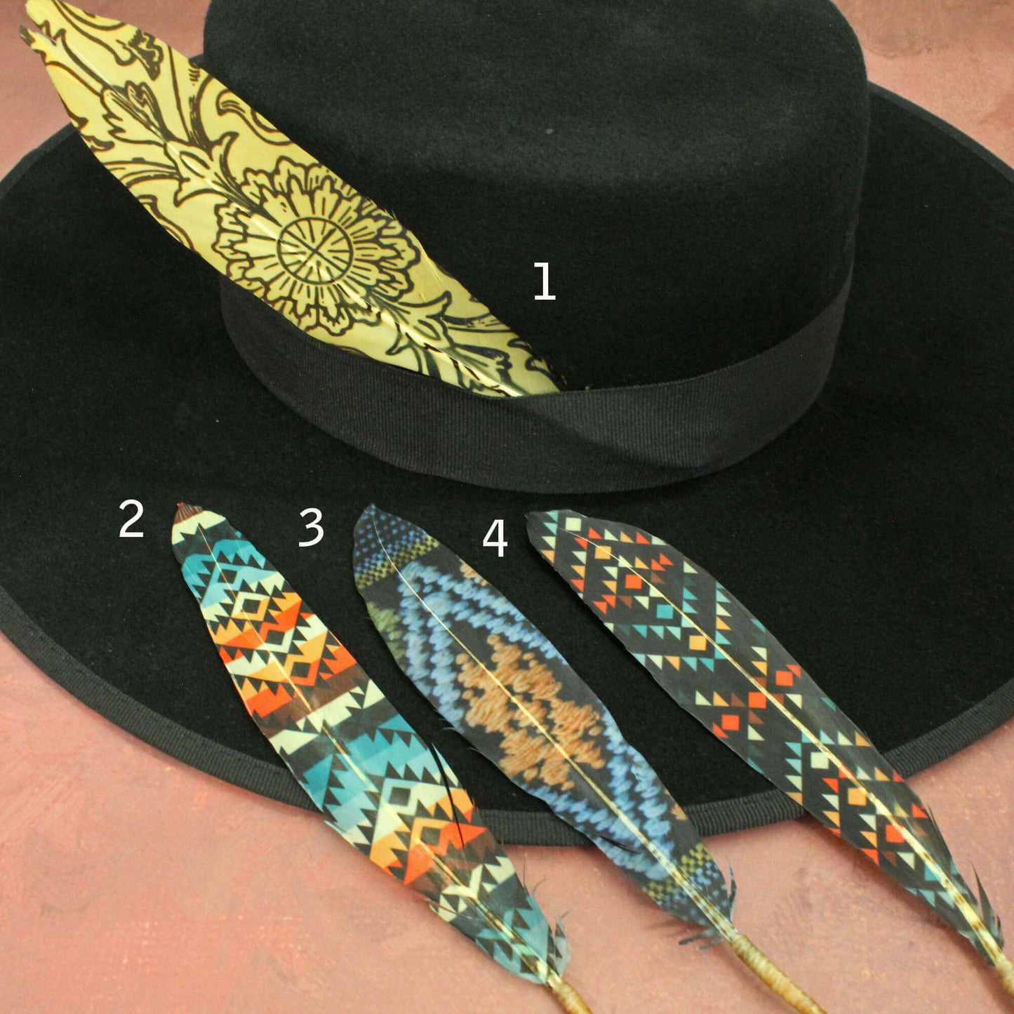 Black hat with decorative feathers featuring geometric patterns on a person's arm.