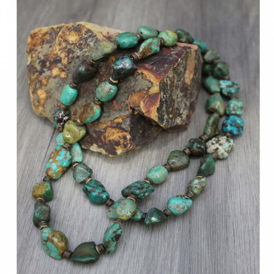 Chunky beaded necklace features genuine natural turquoise stones. Due to the nature of the stones, they will vary in size and color, as pictured. Mix and match from pieces of the same collection to create your own look. Entire length of necklace is 36 inches, including the extender chain. The necklace can be adjusted with the self-tie closure. Beads will range in size from 12-20mm. Made in America