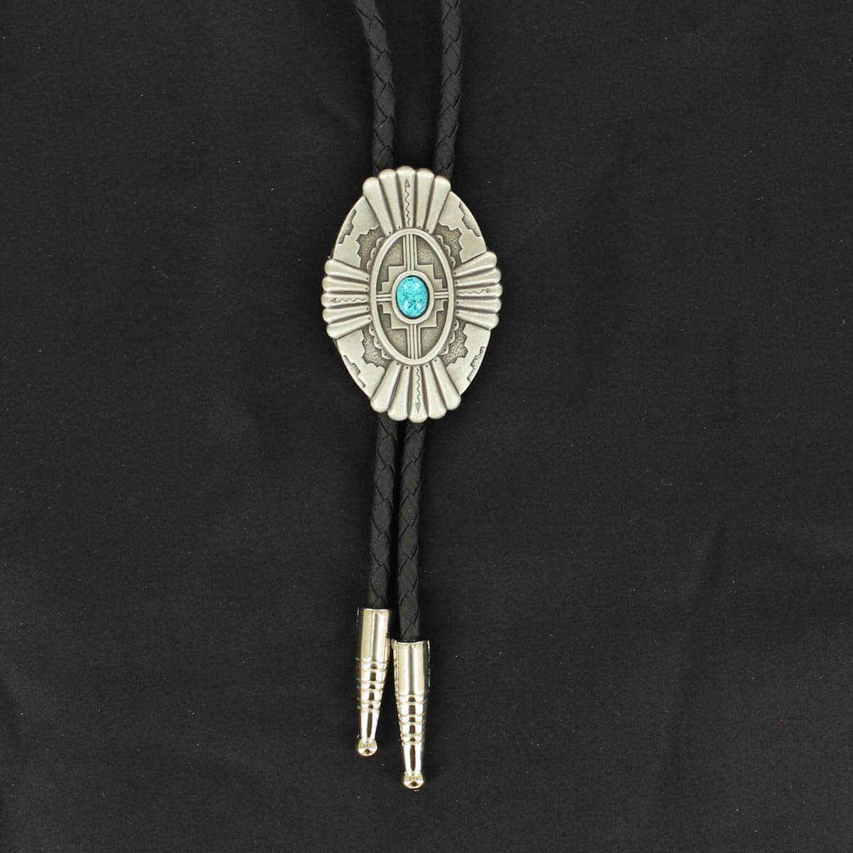 A bolo tie with a silver-colored concho featuring an oval turquoise stone, black braided strings, and silver tips.