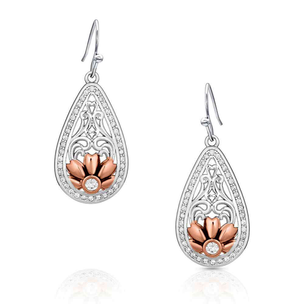 Accented with a beautiful rose gold finished flower these medium sized teardrop earrings begin with flowing open filigree going down to the rose gold pedaled flower with a large clear stone set in the center. The outside of the earring is lined with small clear stones accepting the inner design. Earrings sway from hypoallergenic French hooks.