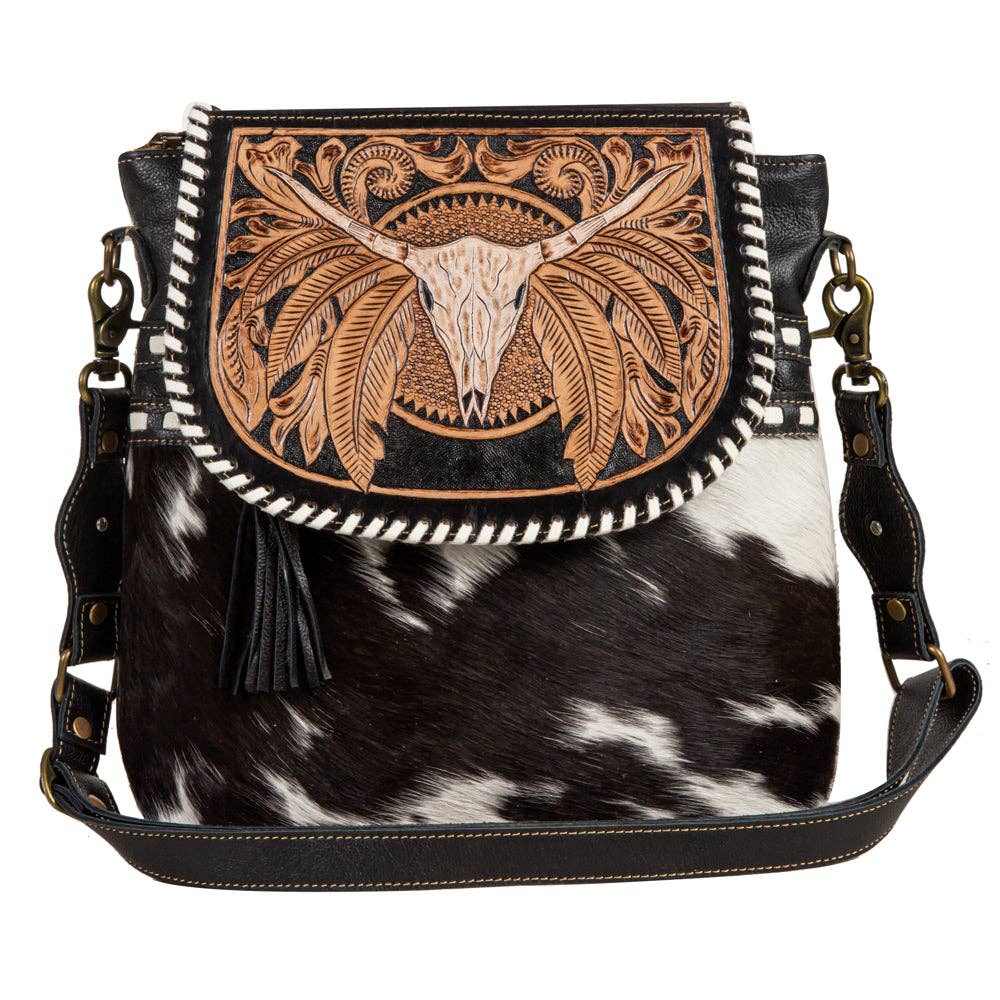 Cowhide leather bag with decorative bull skull design on a white background