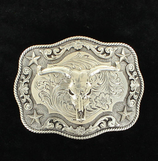 An antique silver belt buckle with a steer skull motif in the center, set against a black background with a scroll pattern.