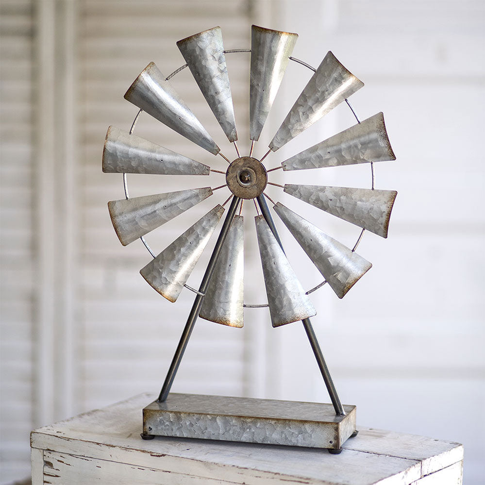 This classic farmhouse tabletop windmill is crafted from durable metal. This vintage-inspired accent piece is designed to add charm and character to any room in your home. The wheel spins effortlessly, adding movement and interest to your décor. Whether placed on a mantel, bookshelf, or coffee table, this windmill is sure to captivate your guests and become a beloved piece in your collection. 