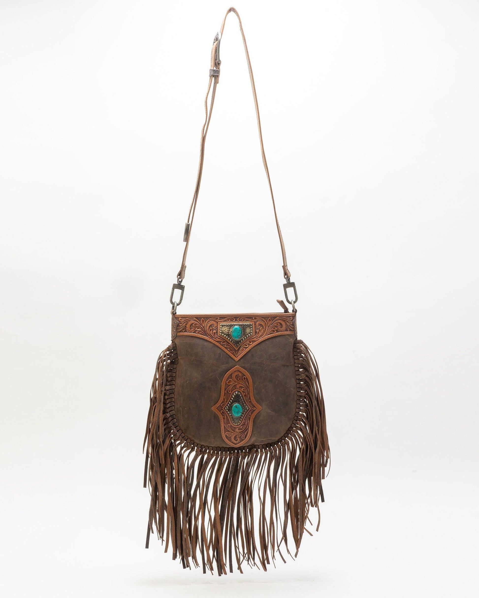 Brown leather handbag with fringe and turquoise accents on a white background