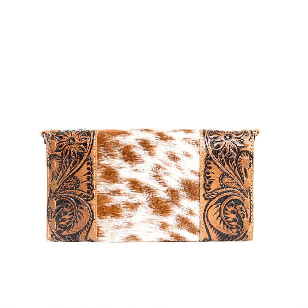 Clutch bag with cowhide pattern and floral tooling on a white background