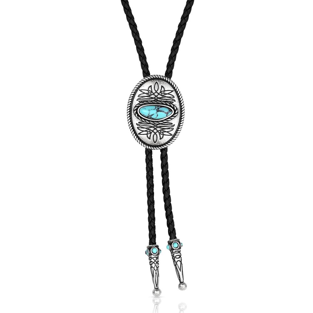 A silver-toned bolo tie necklace featuring a central oval medallion with turquoise-colored stones and intricate engraved details, suspended on a black braided cord with matching turquoise accents near the ends.