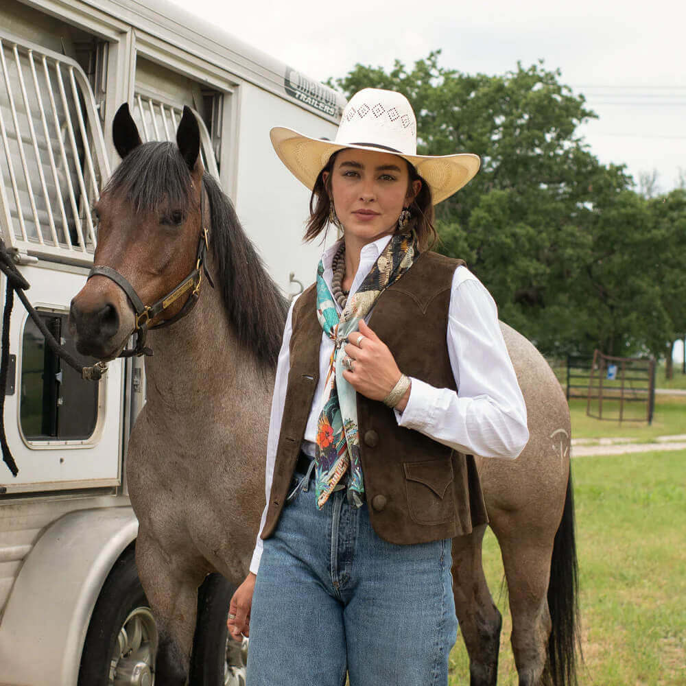Broken Spoke Western Silk Wild Rag styled with a western outfit featuring a horse and vintage trailer in the background.