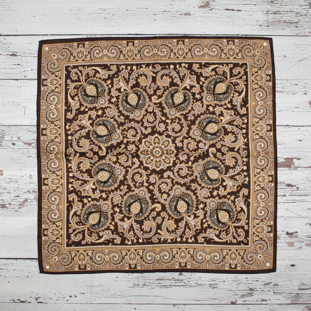 Decorative square western  paisley silk scarf with intricate pattern on a gray floor