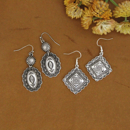 Cool effortless cowgirl silver etched Southwest earrings. These cowgirl earrings are the perfect go-to earrings. Antique silver in a unique design on diamond shaped earrings or oval dangle. Antique silver hypo-allergenic ear wires. Dangle pair measure about 2" long and 7/8" wide oval Concho. Diamond shape measure 1" by 1"