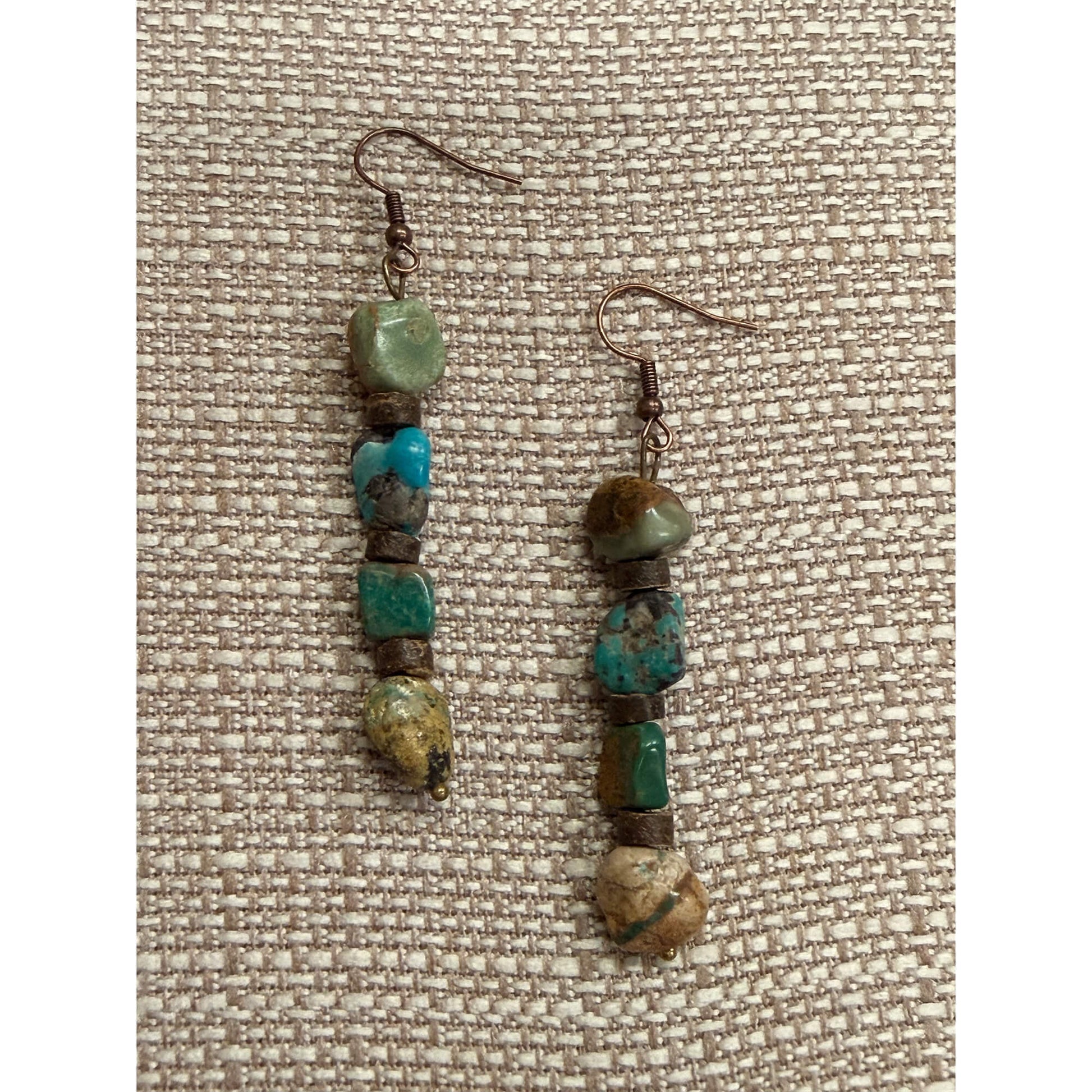 Pair of beaded earrings on a textured fabric background