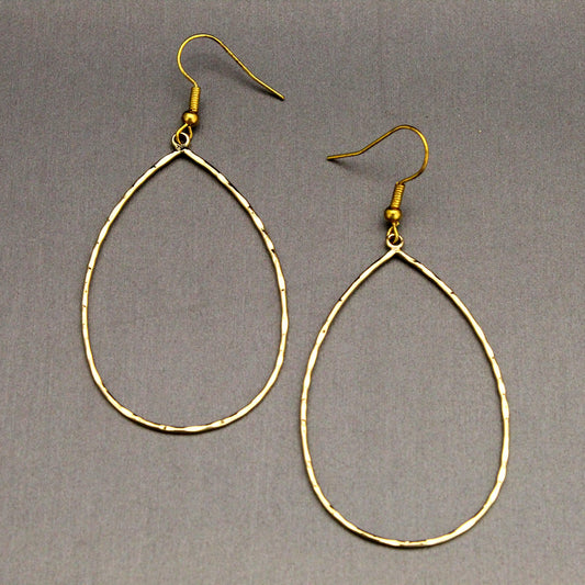 A pair of gold-tone teardrop hoop dangle earrings with textured, hammered edges and fishhook backings, displayed on a neutral gray background.