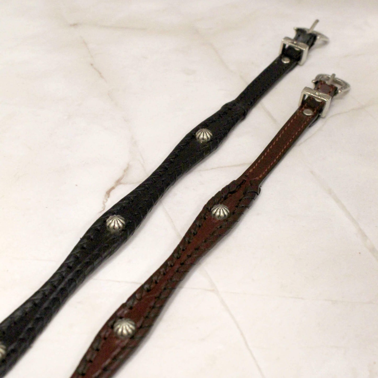 Show your western style with the Leather Cowboy Hatband with Studs - the perfect accessory to add a touch of rugged sophistication to any hat.

• Scalloped leather design with shimmering silver studs
• Adjustable silver western buckle closure to fit most hats
• Available in classic black or rich brown