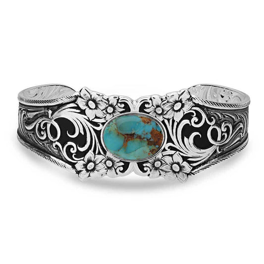 Silver bracelet with floral patterns and a turquoise stone on a white background