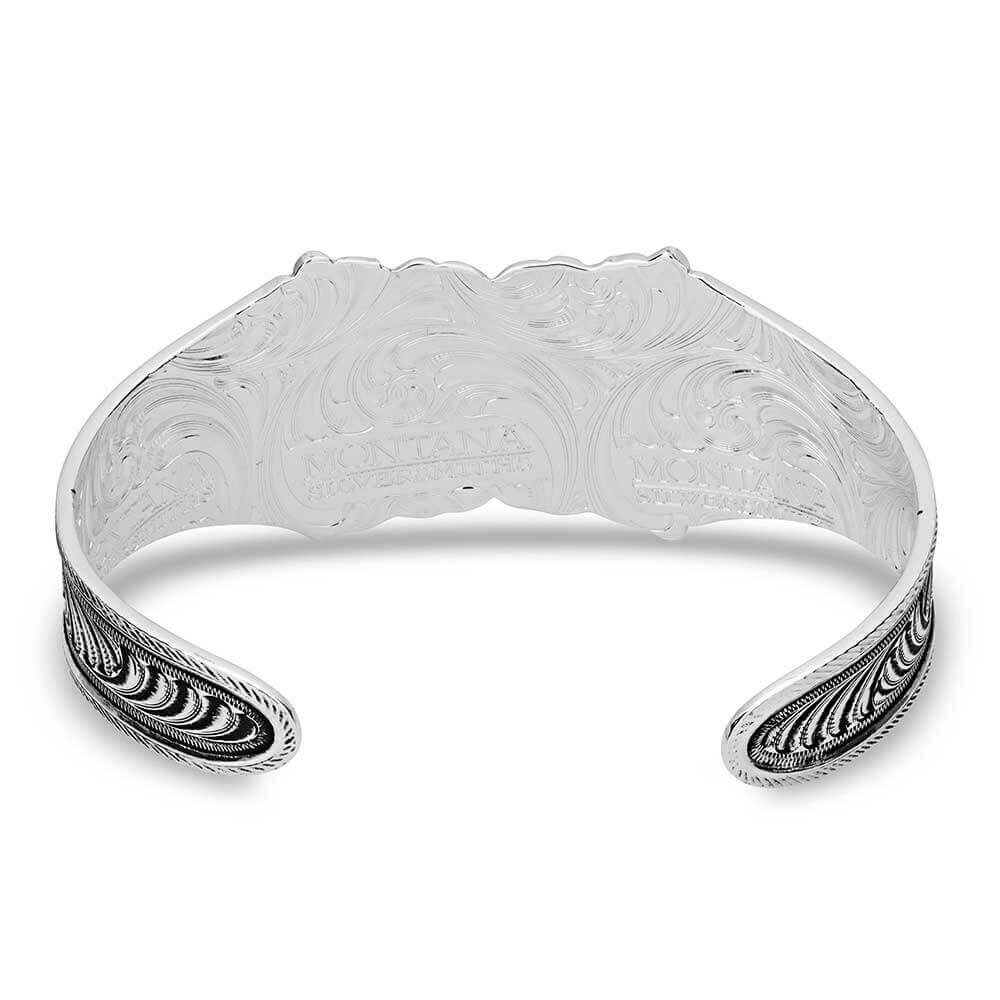 Silver bracelet with intricate designs on a white background