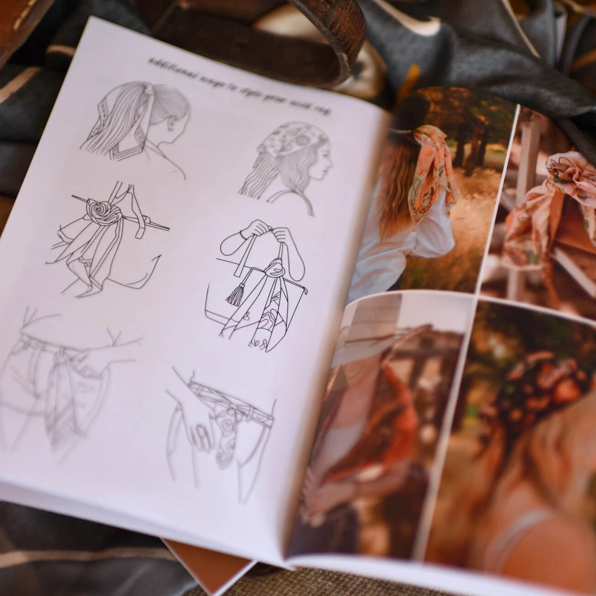 An open fashion design book or sketchbook lying on a textured fabric surface. The left page contains black line drawings of garment silhouettes and accessories, while the right page shows printed photos of a woman wearing a flowing pink scarf and styled outfits.