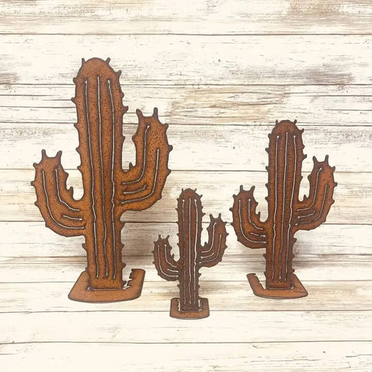 Three rusted metal cactus-shaped Figures displayed on a light whitewashed wooden plank background.