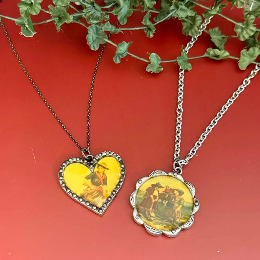 Two necklaces with heart and round yellow pendants on a red background with green leaves.