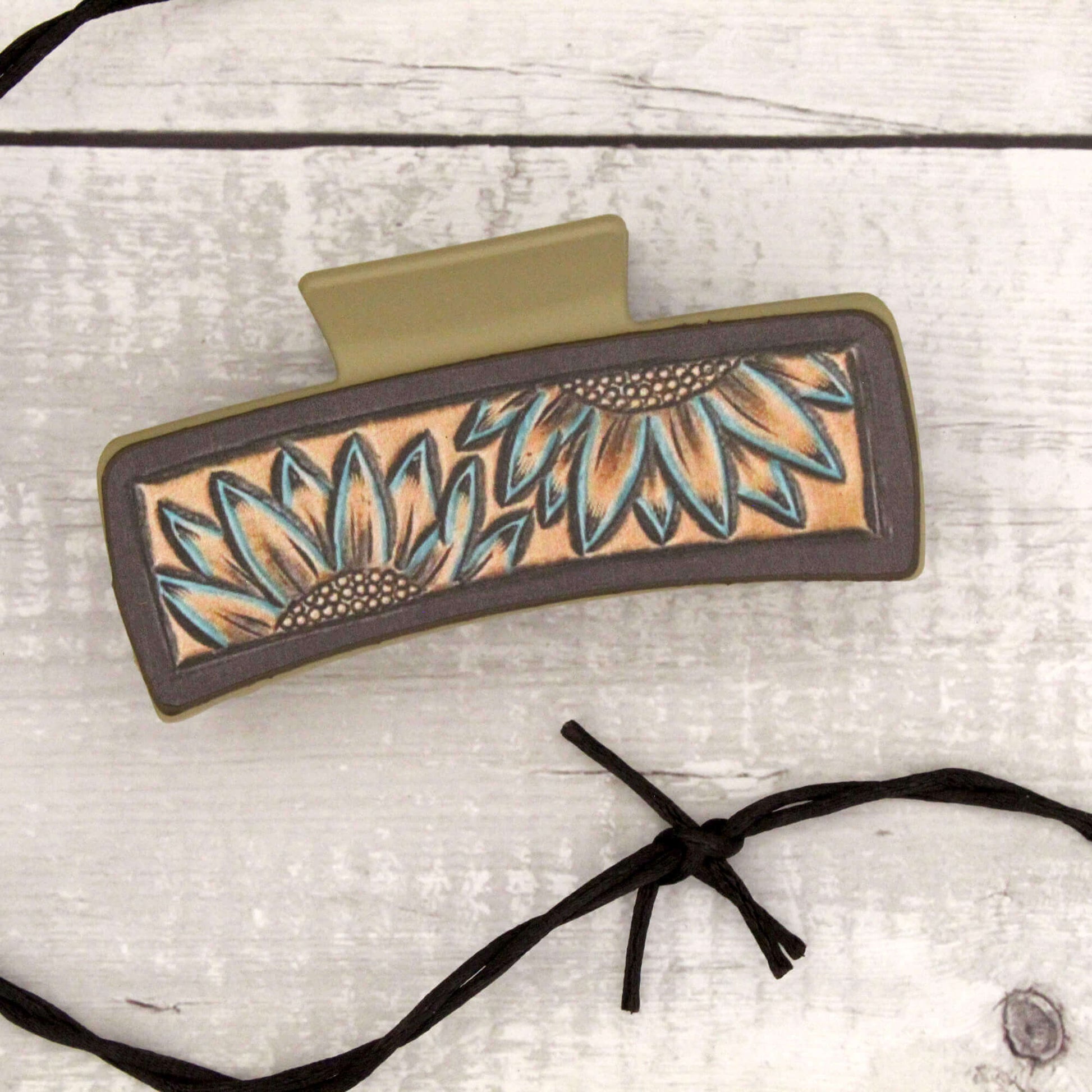 Decorative hair clip with sunflower design on a light wooden background