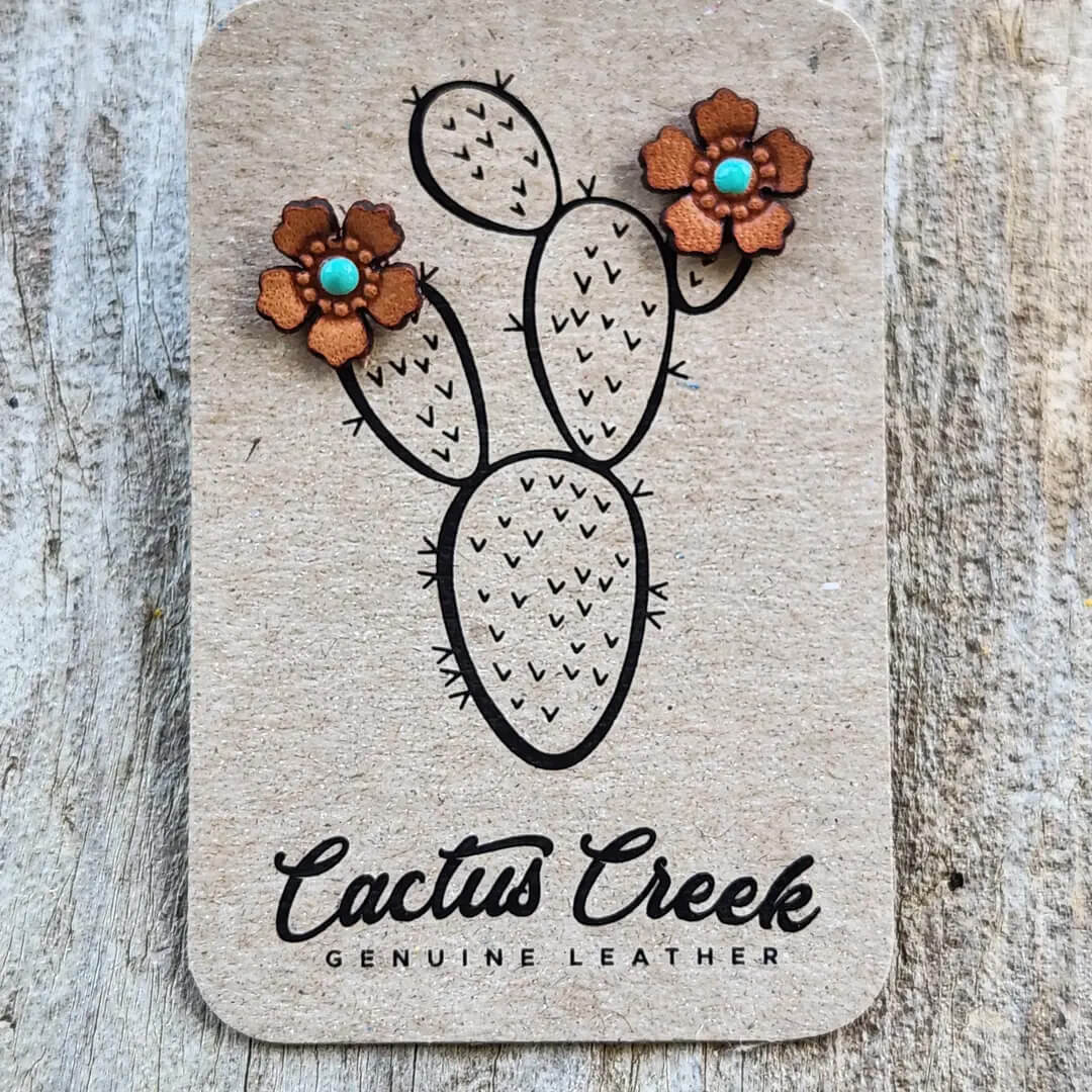 Leather earrings shaped like a cactus with flowers on a Cactus Creek branded card.
