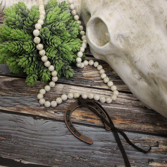 Handcrafted in the USA, this bohemian-style piece measures 46 inches in length, allowing for versatile styling options—layer it for a bold statement or wrap it around your head for a unique twist. The large horseshoe pendant, measuring 2.75" x 2.25", is complemented by a chic brown tassel. Embrace your free spirit and showcase your individuality with this eye-catching necklace that effortlessly blends rustic charm with modern flair.