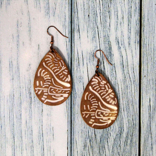 Make a statement with these eye-catching White Floral Stamped Leather Earrings. The beautiful teardrop shape features a delicate floral design stamped into the smooth leather, adding feminine charm.