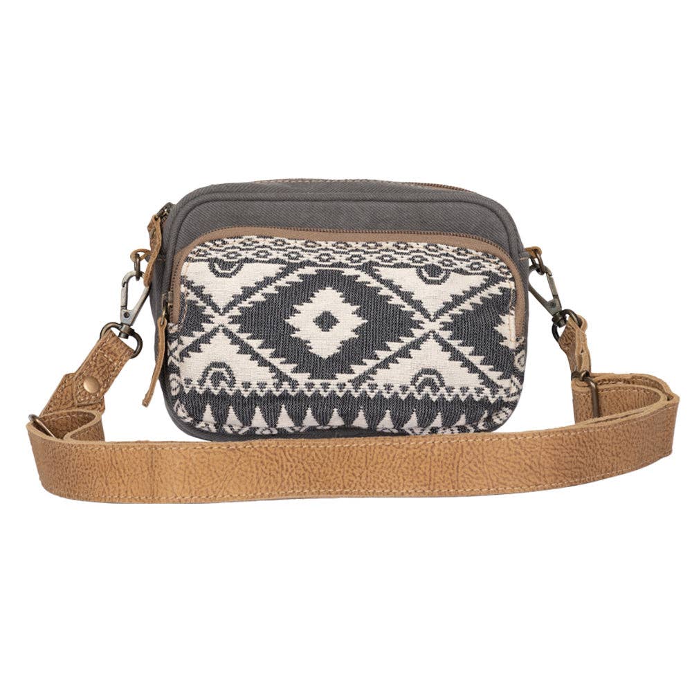 Crossbody bag with geometric pattern and brown strap on a white background