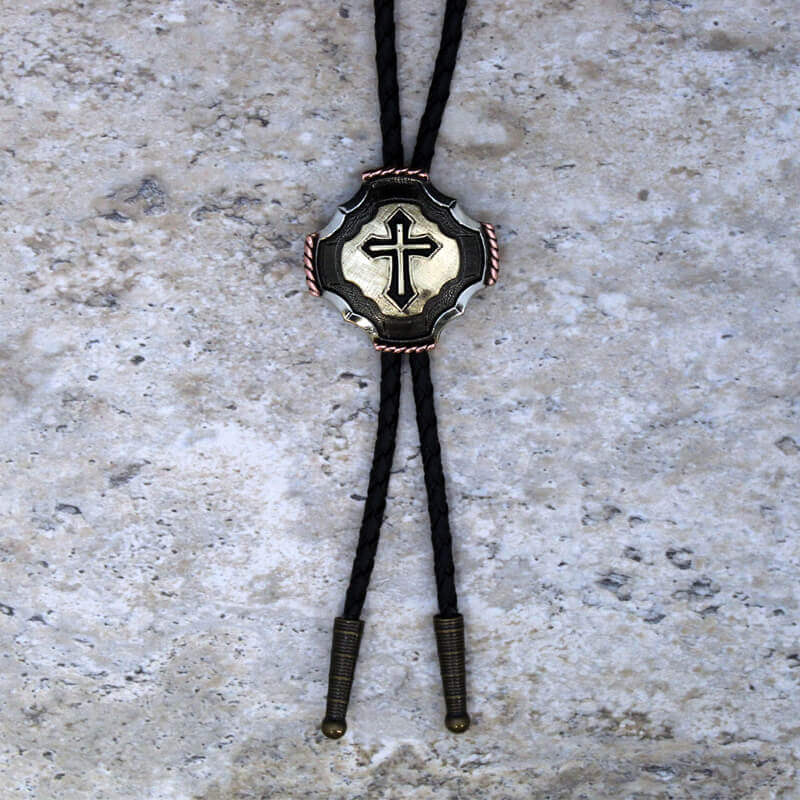Bolo tie with cross design on a textured surface