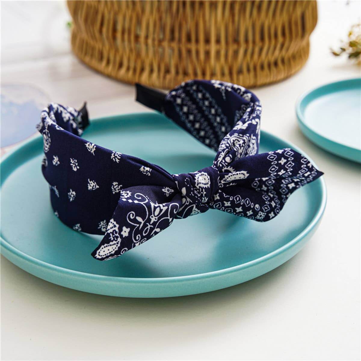 Bandana Bow Headbands featuring a stylish navy blue design and charming bow detail on a turquoise plate.