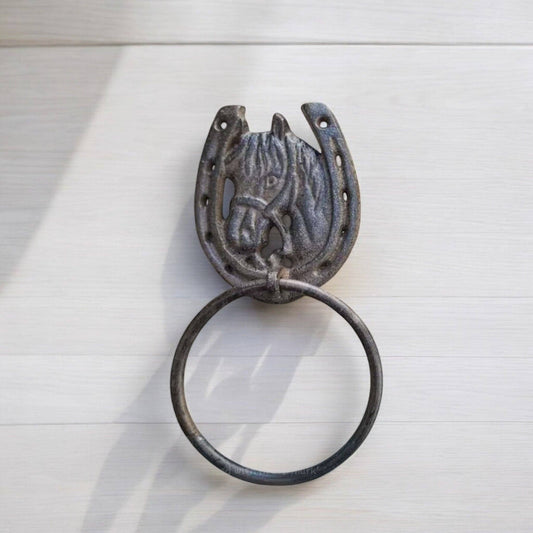 Decorative metal towel ring with horse head design on a white background