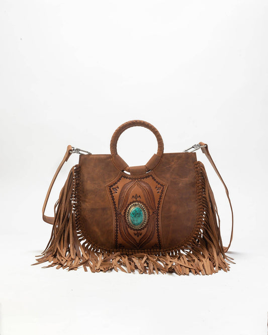 Brown leather handbag with fringe and turquoise stone on a white background